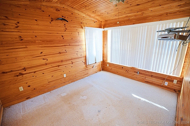 carpeted empty room with wood ceiling, wooden walls, and lofted ceiling