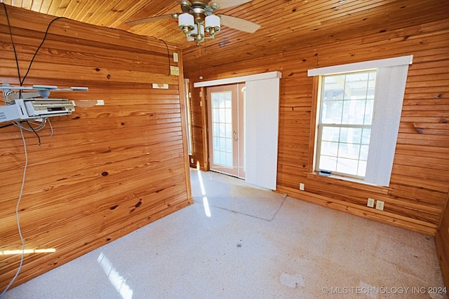 carpeted empty room with wooden walls, ceiling fan, and wood ceiling