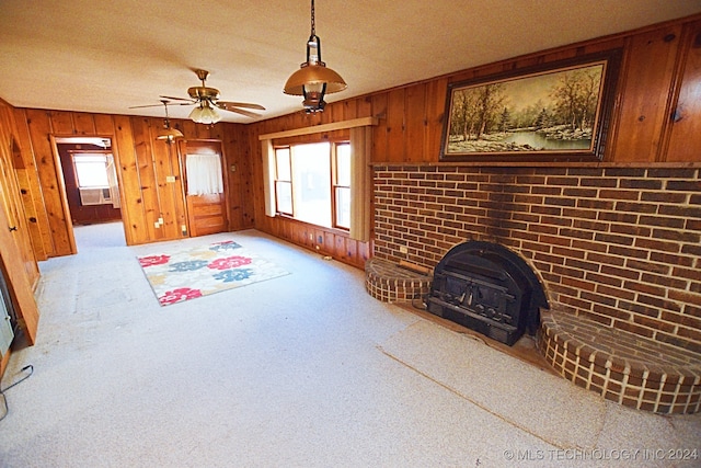 living room with wood walls, light colored carpet, ceiling fan, and brick wall