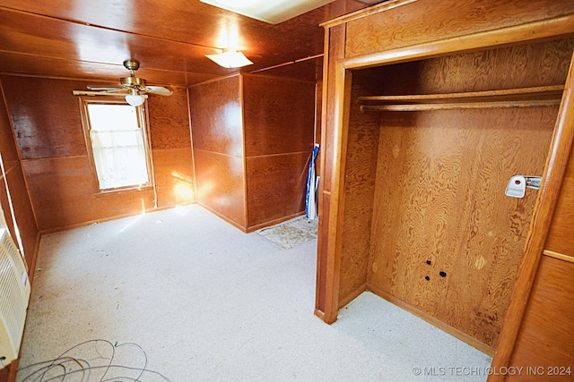 unfurnished bedroom featuring a closet and wooden walls