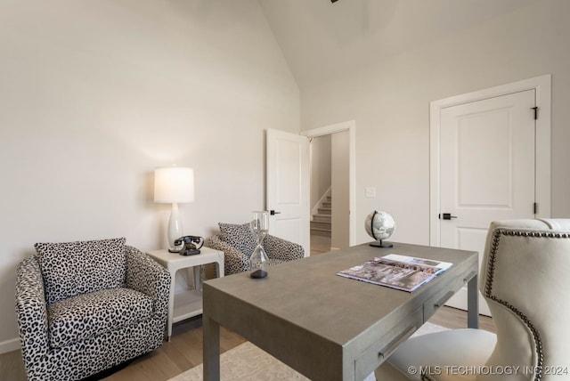 office featuring high vaulted ceiling and light hardwood / wood-style flooring