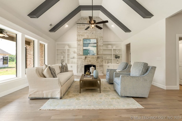 living room featuring high vaulted ceiling, light wood-type flooring, and a fireplace