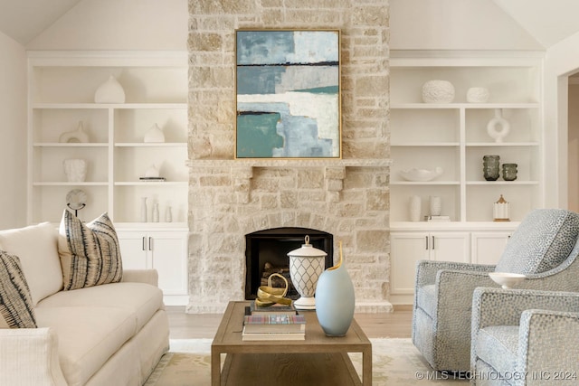 living room with light hardwood / wood-style flooring, lofted ceiling, and built in features