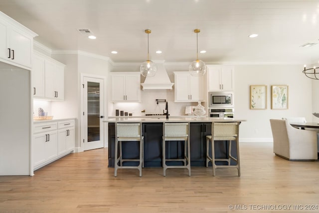 kitchen featuring white cabinetry, appliances with stainless steel finishes, and hanging light fixtures