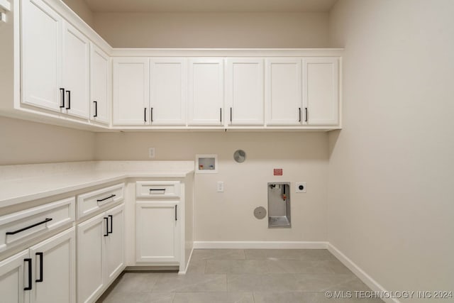 laundry area with hookup for an electric dryer, hookup for a washing machine, hookup for a gas dryer, light tile patterned floors, and cabinets