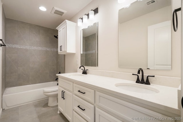 full bathroom featuring vanity, tiled shower / bath, and toilet