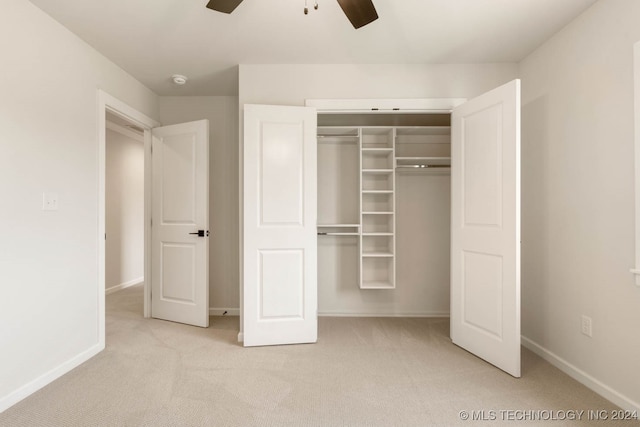 unfurnished bedroom featuring light carpet, ceiling fan, and a closet