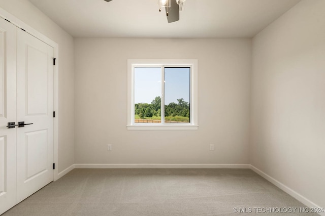 spare room with light carpet and ceiling fan