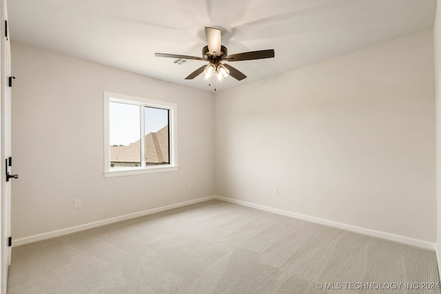 carpeted spare room with ceiling fan