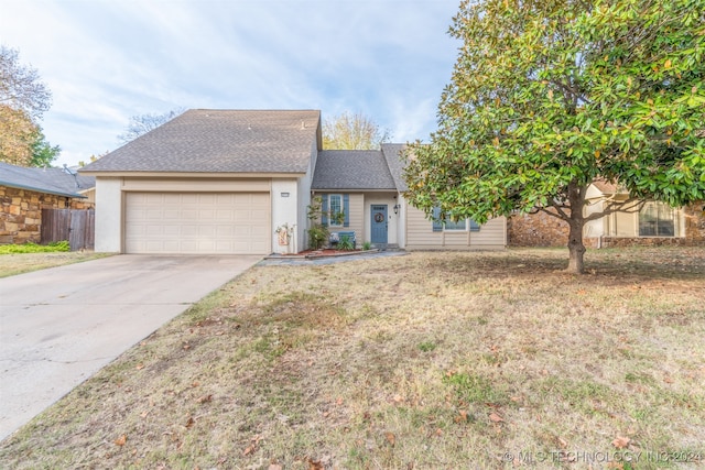 view of front of home featuring a front yard and a garage