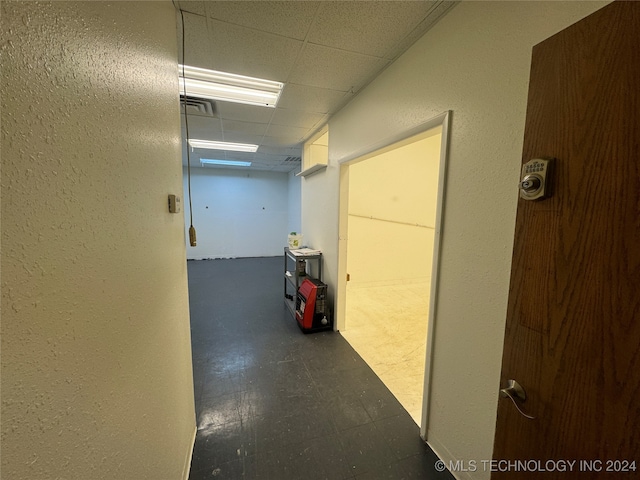 hall featuring a paneled ceiling