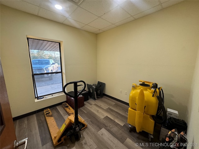 exercise area featuring dark wood-type flooring and a drop ceiling