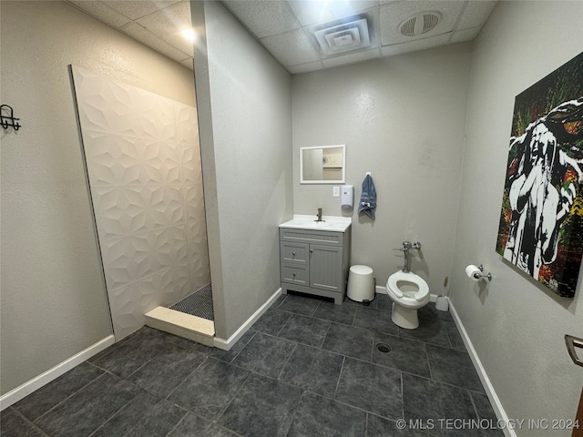 bathroom featuring a shower, a paneled ceiling, tile patterned floors, and toilet