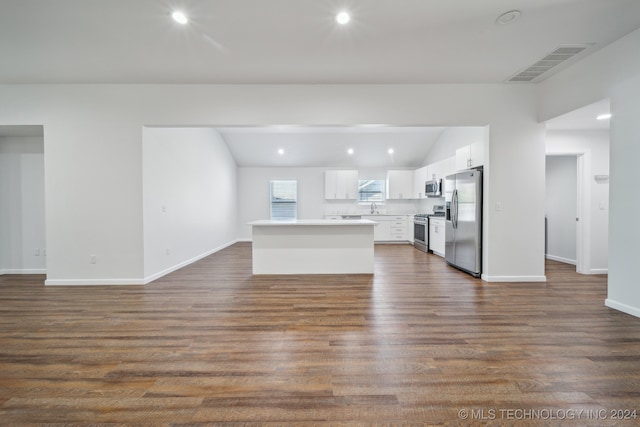 unfurnished living room with sink, vaulted ceiling, and dark hardwood / wood-style floors