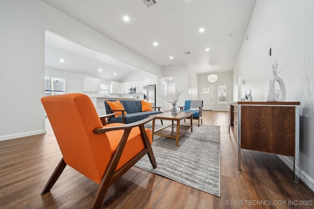 living room featuring dark hardwood / wood-style flooring and vaulted ceiling