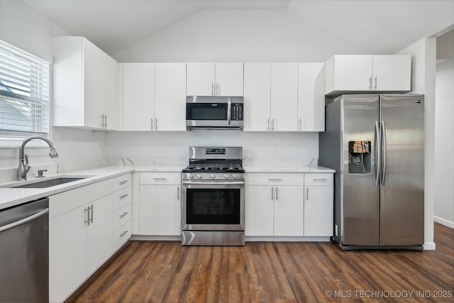 kitchen with dark wood-type flooring, stainless steel appliances, sink, and white cabinets