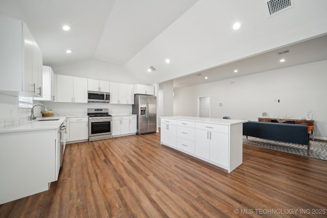 kitchen with appliances with stainless steel finishes, sink, white cabinets, and dark hardwood / wood-style flooring