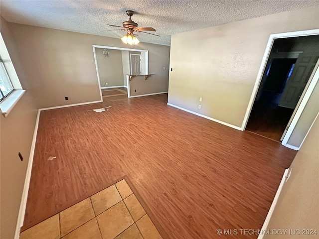 spare room featuring hardwood / wood-style flooring, ceiling fan, and a textured ceiling