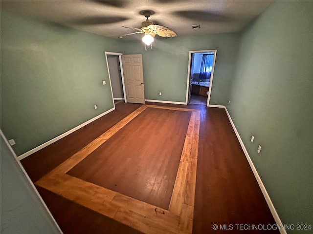 unfurnished bedroom with ceiling fan, connected bathroom, and dark hardwood / wood-style flooring