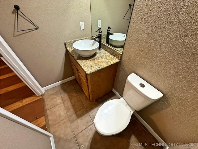 bathroom featuring vanity, tile patterned flooring, and toilet