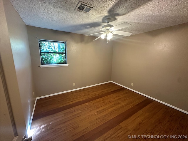 empty room featuring ceiling fan, hardwood / wood-style floors, and a textured ceiling