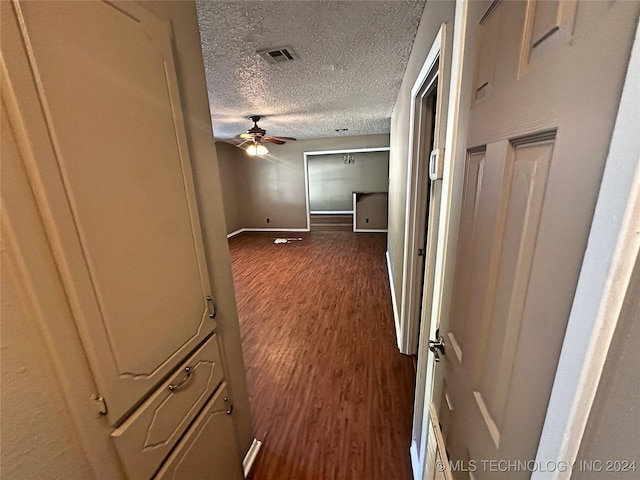 hallway featuring dark hardwood / wood-style floors and a textured ceiling