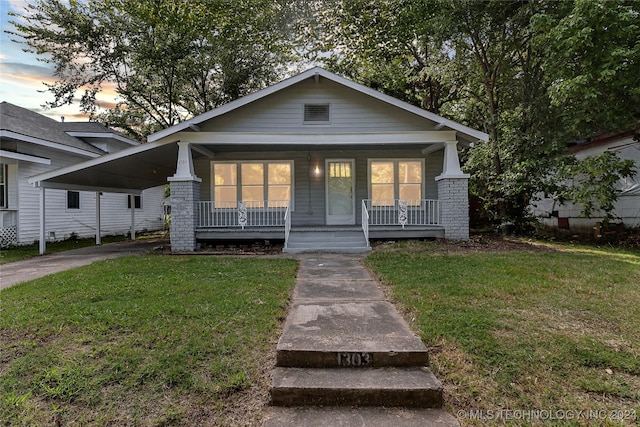 bungalow-style house with a lawn and covered porch