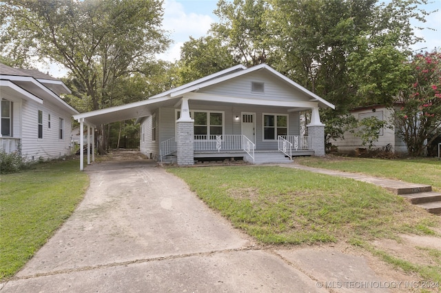 bungalow-style house featuring a front yard, covered porch, and a carport