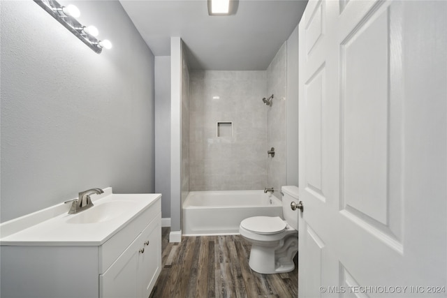 full bathroom featuring toilet, tiled shower / bath combo, vanity, and hardwood / wood-style flooring