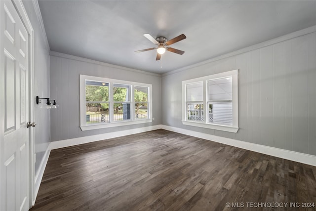 unfurnished room with dark hardwood / wood-style flooring, ceiling fan, wooden walls, and ornamental molding