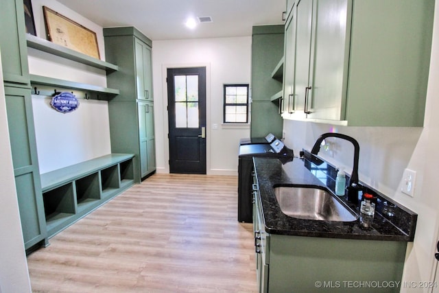 kitchen featuring light wood-type flooring, sink, green cabinets, and stove