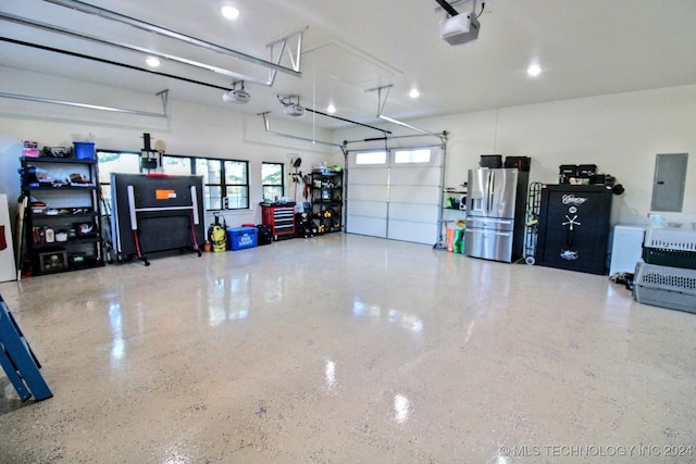 garage featuring a garage door opener, electric panel, and stainless steel fridge with ice dispenser