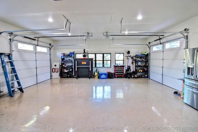 garage featuring a garage door opener and stainless steel fridge