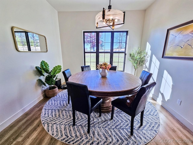 dining space featuring hardwood / wood-style flooring and a chandelier