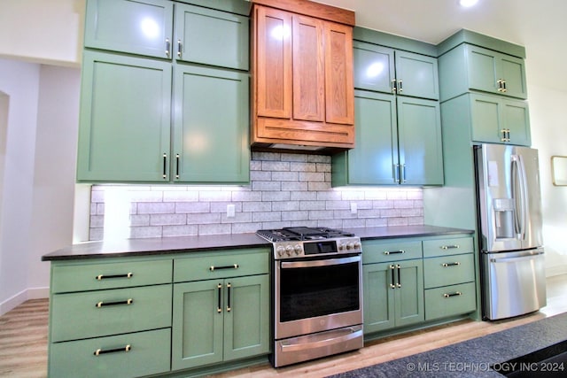 kitchen featuring stainless steel appliances, tasteful backsplash, green cabinets, and light hardwood / wood-style flooring