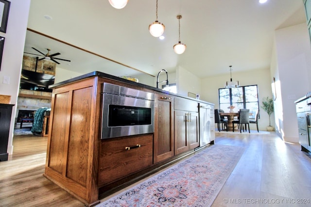 kitchen featuring light hardwood / wood-style flooring, ceiling fan, and decorative light fixtures