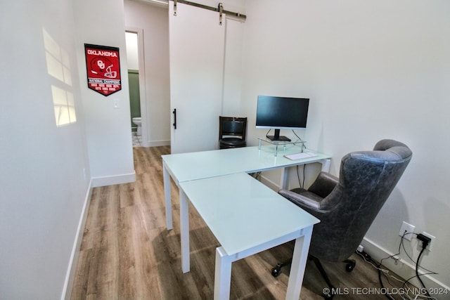 home office featuring a barn door and light wood-type flooring