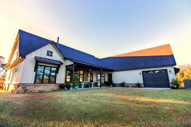 modern farmhouse style home featuring a garage and a yard