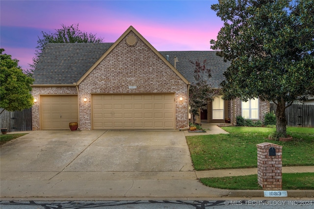 view of front facade featuring a garage and a yard