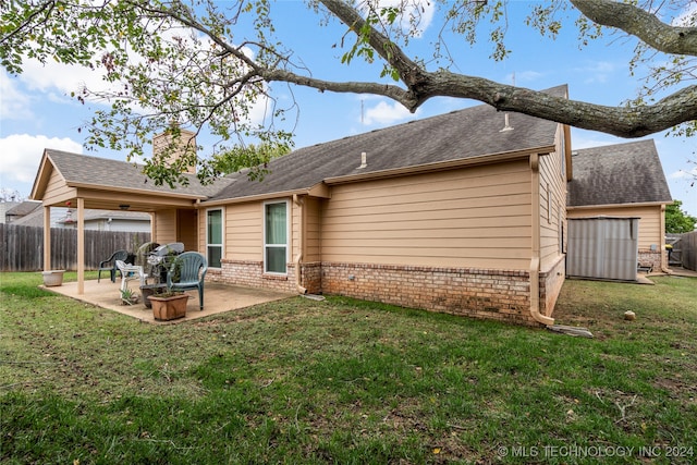 back of property with a lawn and a patio area