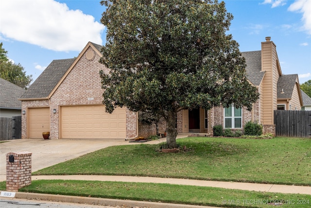 obstructed view of property with a front yard and a garage