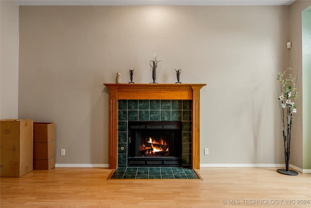 interior details with hardwood / wood-style floors and a tile fireplace