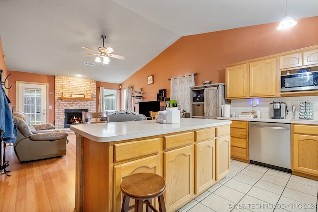 kitchen with hanging light fixtures, ceiling fan, light brown cabinets, and appliances with stainless steel finishes