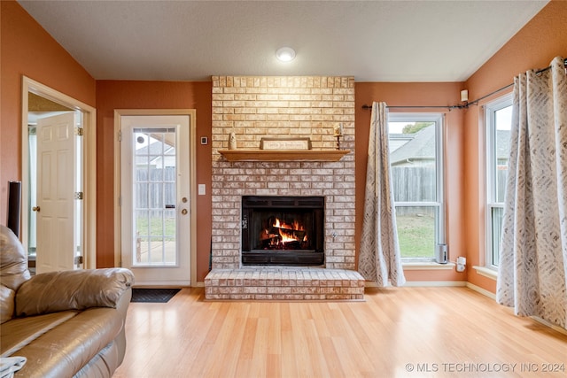 living room featuring a fireplace, hardwood / wood-style flooring, and a textured ceiling