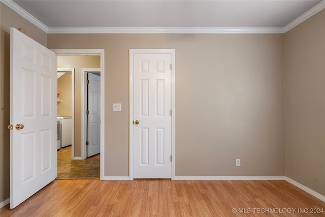 unfurnished bedroom with washer / clothes dryer, ornamental molding, and light hardwood / wood-style flooring