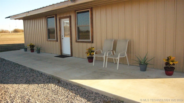 view of exterior entry with a patio area