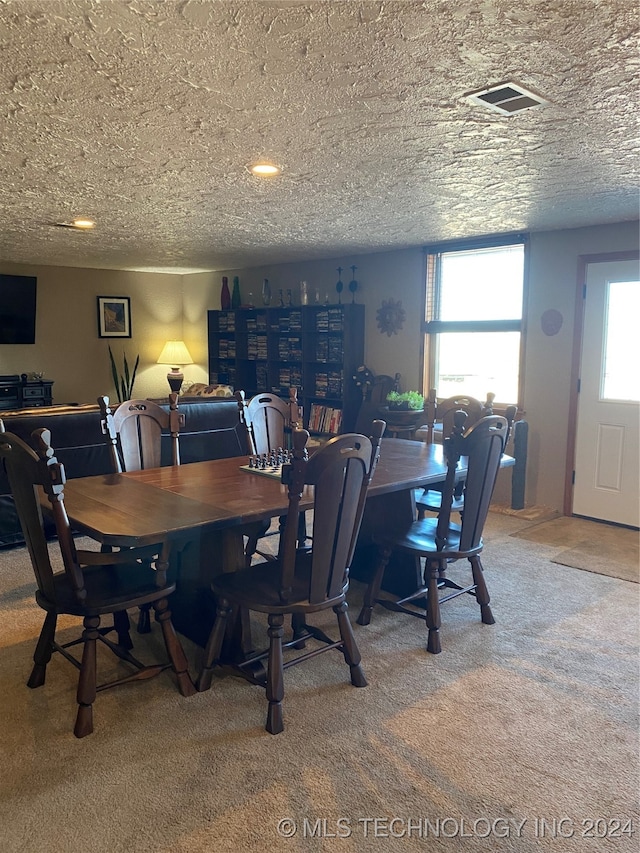 dining room with carpet flooring, a wealth of natural light, and a textured ceiling