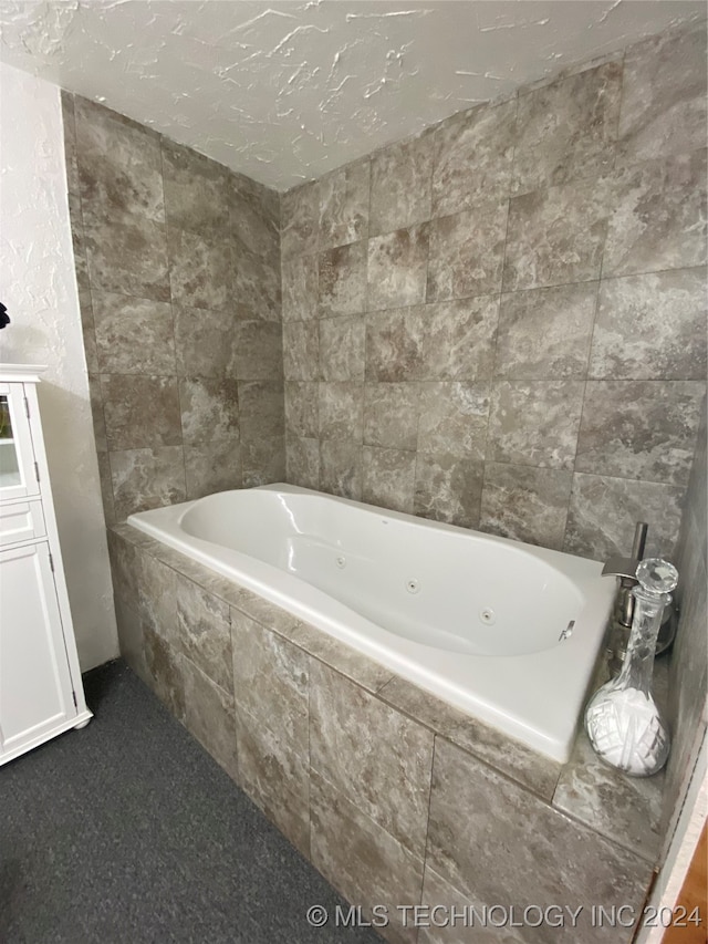 bathroom featuring tiled bath and a textured ceiling