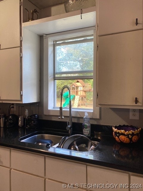 kitchen with white cabinetry and sink