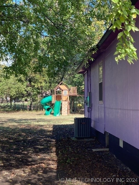 view of yard featuring a playground and central air condition unit